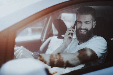 Adamın Tesla arabanın direksiyonuna bir telefon görüşmesi var. Yenilik teknoloji. Yeni nesil Electro hibrid araç. Lüks tasarım. Futuristik güç. Ön koltuk. Cam görünümü.