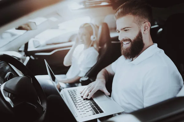 Człowiek Działa Laptopem Dziewczyna Słuchawkach Samochód Tesla Przednie Siedzenie Innowacyjność — Zdjęcie stockowe