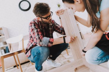 Genç montaj ahşap kitaplık evde çift. Ahşap kitaplık. Selfmade mobilya. Evde aile. Beyaz oda. Mühendis aracı ile. Ev yapımı dekorasyon. Modern mobilya. Kadın araçları ile.