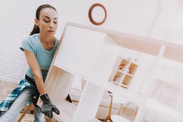 若いカップル自宅の組立木製本棚です 木製の本棚 自作の家具 自宅で家族 白い部屋 ツール エンジニア 自家製の装飾 モダンな家具 ツールを持つ女性 — ストック写真