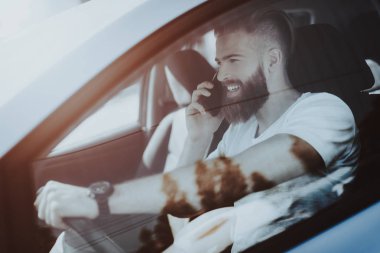 Adamın Tesla arabanın direksiyonuna bir telefon görüşmesi var. Yenilik teknoloji. Yeni nesil Electro hibrid araç. Lüks tasarım. Futuristik güç. Ön koltuk. Cam görünümü.