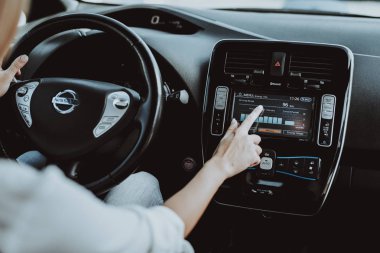 Tesla araba kadında. Arkasında tekerlek kavramı. Yenilik teknoloji. Yeni nesil Electro hibrid araç. Lüks tasarım. Futuristik güç. Ekranda ver. İç görünüm. Ön koltuk.