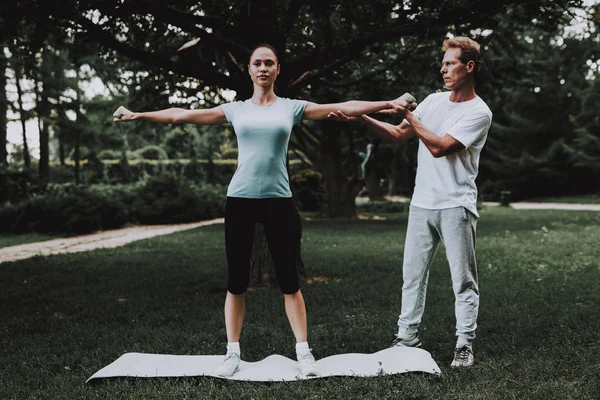 Молода пара в спортивному одязі робить йогу в парку — стокове фото