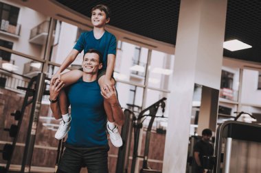 Mutlu baba ve oğul Modern spor kulübünde iyi eğlenceler. Sağlıklı yaşam konsepti. Spor ve eğitim kavramları. Modern spor kulübü. Spor donatımı. Aile spor. Eğitim aparatı. Anne-baba ile çocuk.