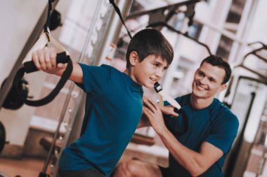 Genç baba ve oğul spor kulübü egzersizleri yapıyor. Sağlıklı yaşam konsepti. Spor ve eğitim kavramları. Modern spor kulübü. Spor donatımı. Aile spor. Eğitim aparatı. Anne-baba ile çocuk.