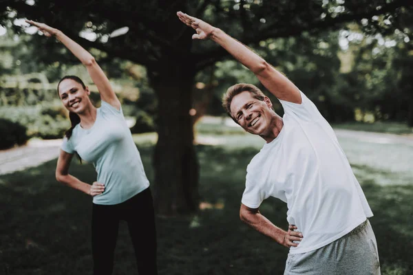 Молода пара в спортивному одязі робити вправи в парку — стокове фото
