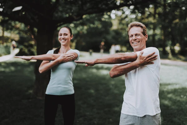 Casal jovem em Sportswear fazendo exercícios no parque — Fotografia de Stock