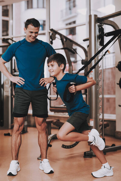 Young Father and Son Doing Exercises in Sport Club