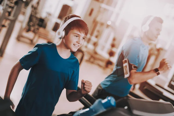 Jóvenes entrenamientos de padre e hijo en cintas de correr en el gimnasio — Foto de Stock