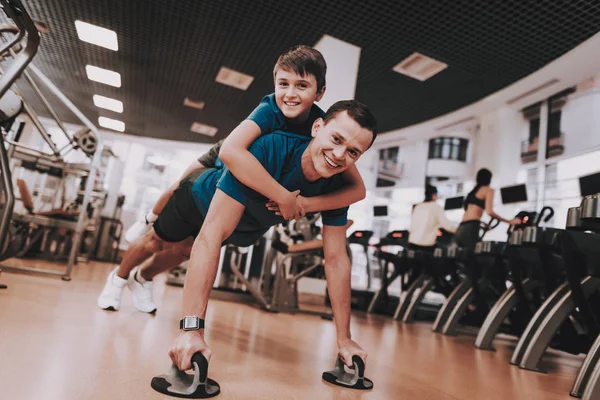 Молодой отец и сын делают упражнения в спортивном клубе — стоковое фото