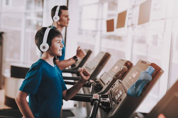 Jóvenes entrenamientos de padre e hijo en cintas de correr en el gimnasio — Foto de Stock