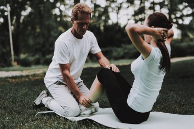 Genç çift Park Yoga yaparken spor giyim. Spor ve sağlık kavramı. Genç adam açık. Yaz Park. Eğlenceli açık. Spor yaz. Eğitmen yaz Park. Gülümseyen genç kadın.