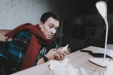 Engelli hasta genç adam tekerlekli sandalye evde. Adam tekerlekli sandalye üzerinde. Engelli adam. Damalı battaniye. Sağlık kavramı. Soğuk ile serbest meslek. Evde hasta adam sağlık. Ahşap masa.