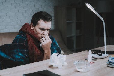 Engelli hasta genç adam tekerlekli sandalye evde. Adam tekerlekli sandalye üzerinde. Engelli adam. Damalı battaniye. Sağlık kavramı. Soğuk ile serbest meslek. Evde hasta adam sağlık. Ahşap masa.