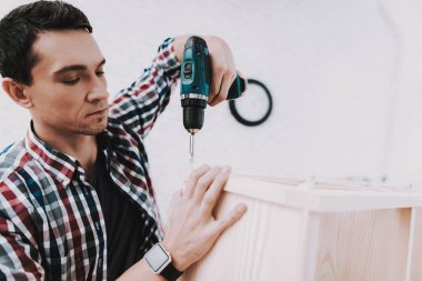 Montaj ahşap kitaplık Evde Genç adam. Ahşap kitaplık. Selfmade mobilya. Adam ve hobi. Beyaz oda. Mühendis aracı ile. Genç adam evde. Ev yapımı dekorasyon. Modern mobilya.