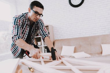 Montaj ahşap kitaplık Evde Genç adam. Ahşap kitaplık. Selfmade mobilya. Adam ve hobi. Beyaz oda. Mühendis aracı ile. Genç adam evde. Ev yapımı dekorasyon. Modern mobilya.
