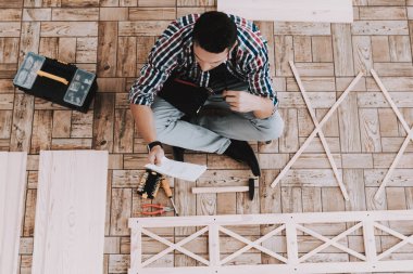 Montaj ahşap kitaplık Evde Genç adam. Ahşap kitaplık. Selfmade mobilya. Adam ve hobi. Beyaz oda. Mühendis aracı ile. Genç adam evde. Ev yapımı dekorasyon. Modern mobilya.