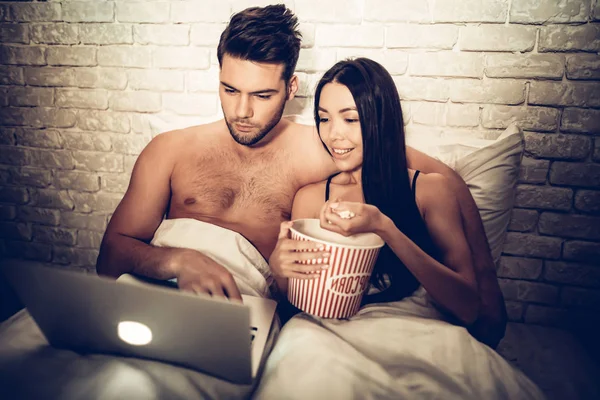 Paar mit Laptop auf Bett liegend Film anschauen — Stockfoto