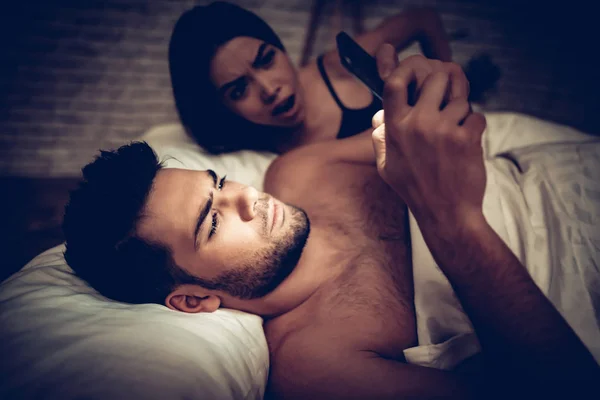 Couple amoureux au lit, Homme utilisant un téléphone portable — Photo