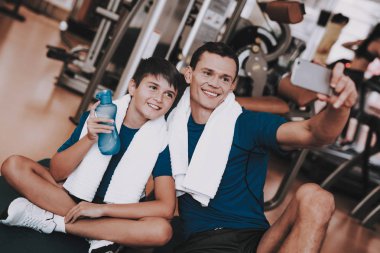 Genç baba ve oğul paspaslar spor kulübü içinde oturan. Sağlıklı yaşam konsepti. Spor ve eğitim kavramları. Modern spor kulübü. Spor donatımı. Aile spor. Eğitimden sonra dinlenme. Anne-baba ile çocuk.