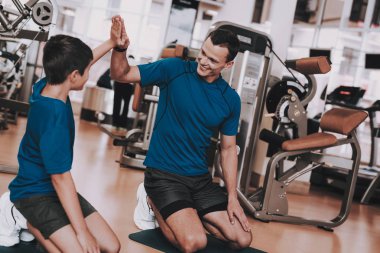 Genç baba ve oğul spor kulübü egzersizleri yapıyor. Sağlıklı yaşam konsepti. Spor ve eğitim kavramları. Modern spor kulübü. Spor donatımı. Aile spor. Koşu izler. Anne-baba ile çocuk.