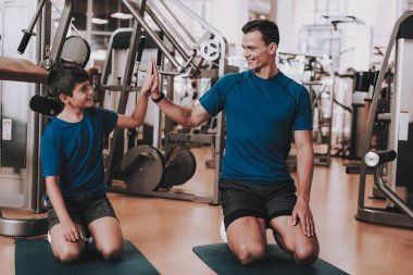 Genç baba ve oğul spor kulübü egzersizleri yapıyor. Sağlıklı yaşam konsepti. Spor ve eğitim kavramları. Modern spor kulübü. Spor donatımı. Aile spor. Koşu izler. Anne-baba ile çocuk.