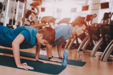 Genç baba ve oğul spor kulübü egzersizleri yapıyor. Sağlıklı yaşam konsepti. Spor ve eğitim kavramları. Modern spor kulübü. Spor donatımı. Aile spor. Koşu izler. Anne-baba ile çocuk.