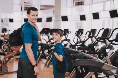 Genç baba ve oğul Modern spor salonunda koşu bandı yakınındaki. Sağlıklı yaşam konsepti. Spor ve eğitim kavramları. Modern spor kulübü. Spor donatımı. Aile spor. Koşu izler. Anne-baba ile çocuk.