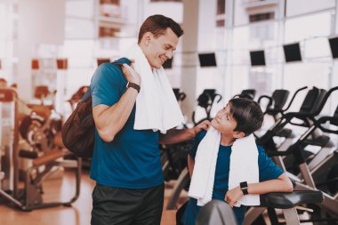 Genç baba ve oğul Modern spor salonunda koşu bandı yakınındaki. Sağlıklı yaşam konsepti. Spor ve eğitim kavramları. Modern spor kulübü. Spor donatımı. Aile spor. Koşu izler. Anne-baba ile çocuk.