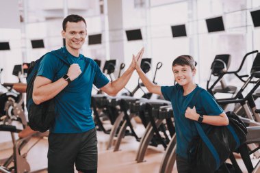 Genç baba ve oğul Modern spor salonunda koşu bandı yakınındaki. Sağlıklı yaşam konsepti. Spor ve eğitim kavramları. Modern spor kulübü. Spor donatımı. Aile spor. Koşu izler. Anne-baba ile çocuk.