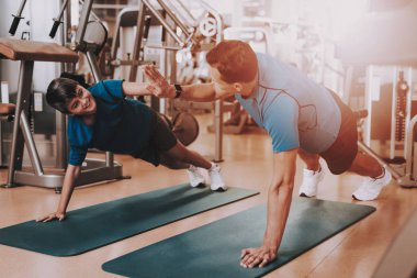 Genç baba ve oğul spor kulübü egzersizleri yapıyor. Sağlıklı yaşam konsepti. Spor ve eğitim kavramları. Modern spor kulübü. Spor donatımı. Aile spor. Koşu izler. Anne-baba ile çocuk.