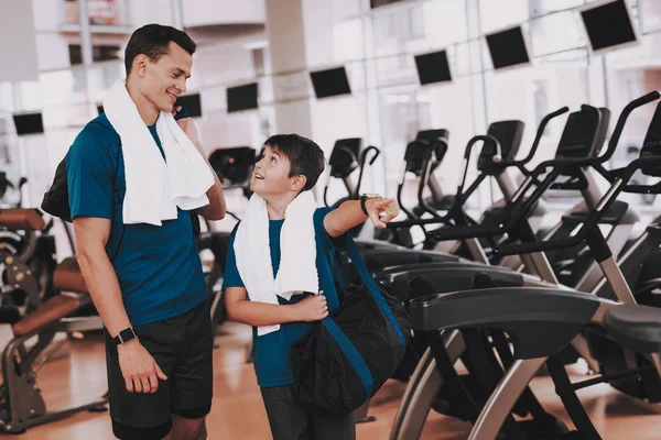 Genç baba ve oğul Modern spor salonunda koşu bandı yakınındaki. Sağlıklı yaşam konsepti. Spor ve eğitim kavramları. Modern spor kulübü. Spor donatımı. Aile spor. Koşu izler. Anne-baba ile çocuk.