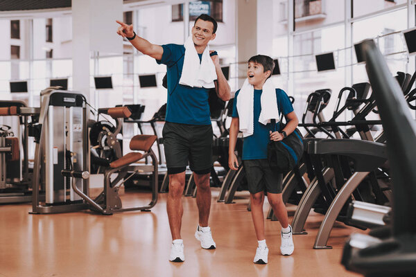 Young Father and Son near Treadmills in Modern Gym. Healthy Lifestyle Concept. Sport and Training Concepts. Modern Sport Club. Sport Equipment. Family Sport. Running Tracks. Parent with Child.