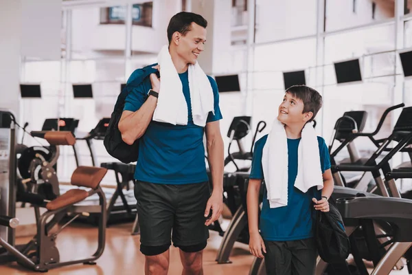 Genç baba ve oğul Modern spor salonunda koşu bandı yakınındaki. Sağlıklı yaşam konsepti. Spor ve eğitim kavramları. Modern spor kulübü. Spor donatımı. Aile spor. Koşu izler. Anne-baba ile çocuk.