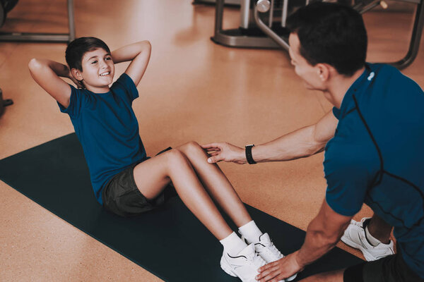 Young Father and Son Doing Exercises in Sport Club. Healthy Lifestyle Concept. Sport and Training Concepts. Modern Sport Club. Sport Equipment. Family Sport. Running Tracks. Parent with Child.