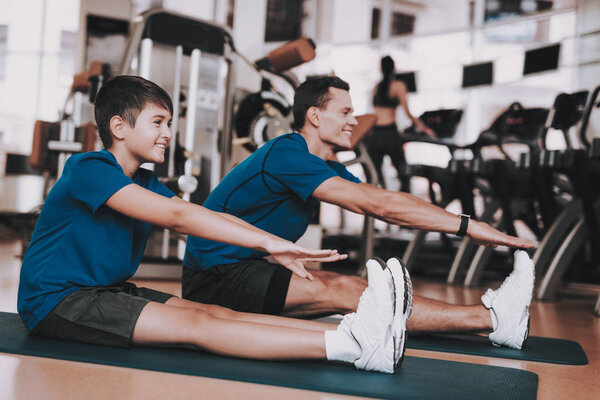 Young Father and Son Doing Exercises in Sport Club. Healthy Lifestyle Concept. Sport and Training Concepts. Modern Sport Club. Sport Equipment. Family Sport. Running Tracks. Parent with Child.