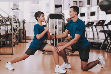 Genç baba ve oğul eğitim salonunda için hazırlanıyor. Sağlıklı yaşam konsepti. Spor ve eğitim kavramları. Modern spor kulübü. Spor donatımı. Aile spor. Koşu izler. Anne-baba ile çocuk.