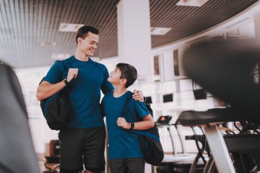 Genç baba ve oğul Modern spor salonunda koşu bandı yakınındaki. Sağlıklı yaşam konsepti. Spor ve eğitim kavramları. Modern spor kulübü. Spor donatımı. Aile spor. Koşu izler. Anne-baba ile çocuk.