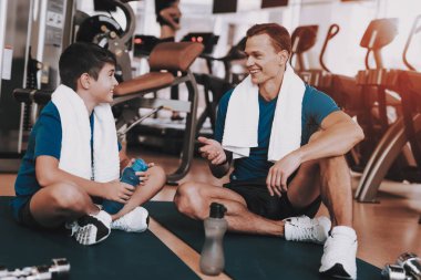 Genç baba ve oğul paspaslar spor kulübü içinde oturan. Sağlıklı yaşam konsepti. Spor ve eğitim kavramları. Modern spor kulübü. Spor donatımı. Aile spor. Eğitimden sonra dinlenme. Anne-baba ile çocuk.