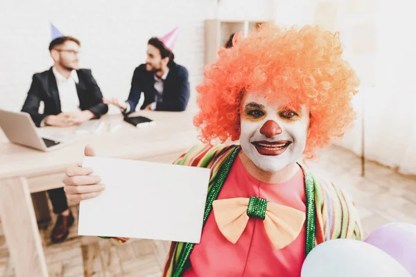 Young Man in Clown Costume on Meeting in Office. April Fools Day. Businessman in Office. April Jokes. Crazy Day. Workers on Meeting. Holidays and Celebration Concept. Clown with Red Nose.