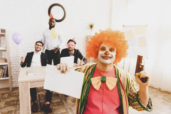 Young Man in Clown Costume on Meeting in Office. April Fools Day. Businessman in Office. April Jokes. Crazy Day. Workers on Meeting. Holidays and Celebration Concept. Clown with Red Nose.