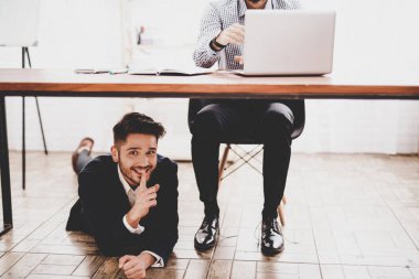 Genç meslektaşım ayakkabı bağcığı bağlama masanın altına. Ofiste iş görüşmesi. Nisan bir gün. Ofiste iş adamı. Nisan şakaları. Tatiller ve kutlama kavramları. Ofis şakalar.
