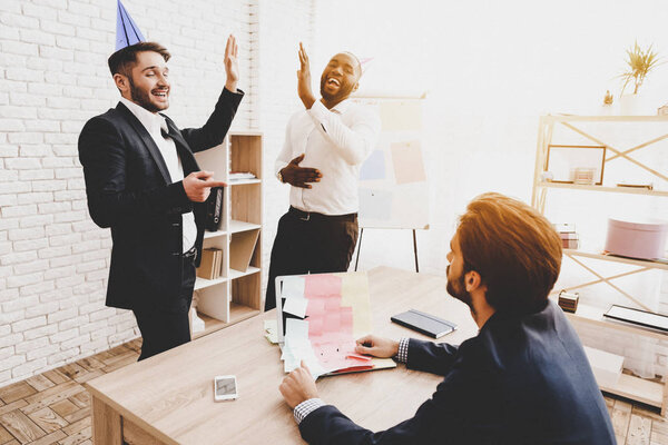 Men Pasted Sticker on Colleague's Laptop in Office. April Fools Day. Businessman in Office. April Jokes. Crazy Day. Laptop in Office. Holidays and Celebration Concept. Jokes in Office.