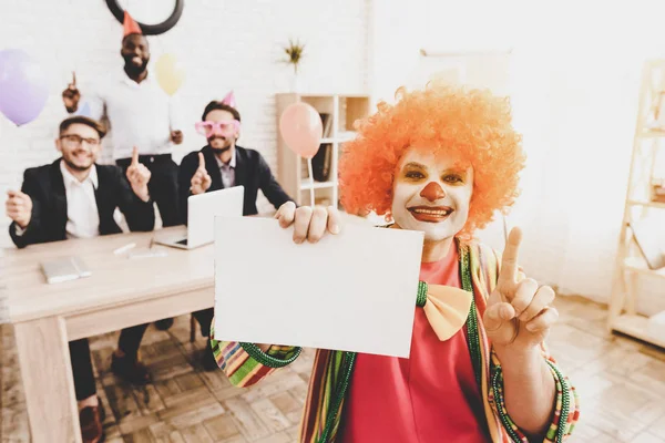 Young Man in Clown Costume on Meeting in Office. April Fools Day. Businessman in Office. April Jokes. Crazy Day. Workers on Meeting. Holidays and Celebration Concept. Clown with Red Nose.
