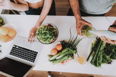 Bir çift bir salata bir kahvaltı için hazırlanıyor. Birlikte yemek... Sağlıklı bir yaşam tarzı. Genç ve yakışıklı. Spor vücut. Evin iç. Sabah taze beslenme kavramı. Blender ile karıştırma.