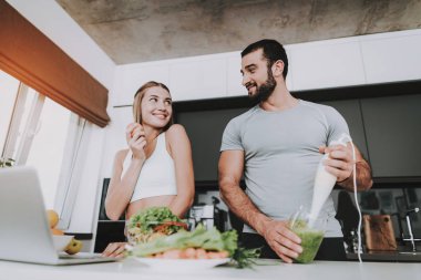 Bir çift bir salata bir kahvaltı için hazırlanıyor. Birlikte yemek... Sağlıklı bir yaşam tarzı. Genç ve yakışıklı. Spor vücut. Evin iç. Sabah taze beslenme kavramı. Blender ile karıştırma.