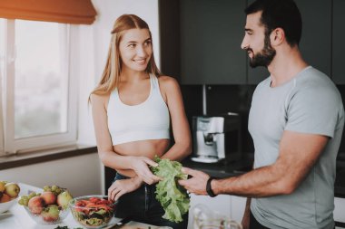 Bir çift bir salata bir kahvaltı için hazırlanıyor. Birlikte yemek... Sağlıklı bir yaşam tarzı. Genç ve yakışıklı. Spor vücut. Evin iç. Çanak doğrama. Sabah taze beslenme kavramı.