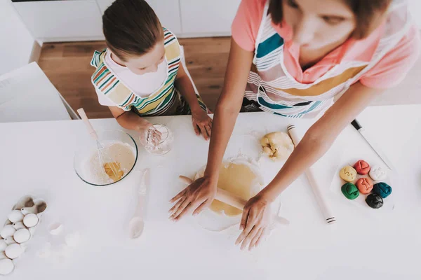 Young Family Is Cooking With Dough At Kitchen. Happy Family Relationship. Making Dish Together. View From Above. Active Holiday Leisure. Roll Out Dough. Learn To Baking. Mother And Daughter.