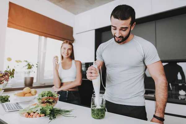 A Couple Is Preparing A Salad For A Breakfast. Cooking Together.. Healthy Lifestyle. Young And Handsome. Sport Body. House Interior. Morning Fresh Nutrition Concept. Mixing With Blender.