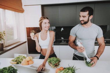 Bir çift bir salata bir kahvaltı için hazırlanıyor. Birlikte yemek... Sağlıklı bir yaşam tarzı. Genç ve yakışıklı. Spor vücut. Birbirlerine bakıyorlar. Çanak doğrama. Sabah taze beslenme kavramı.